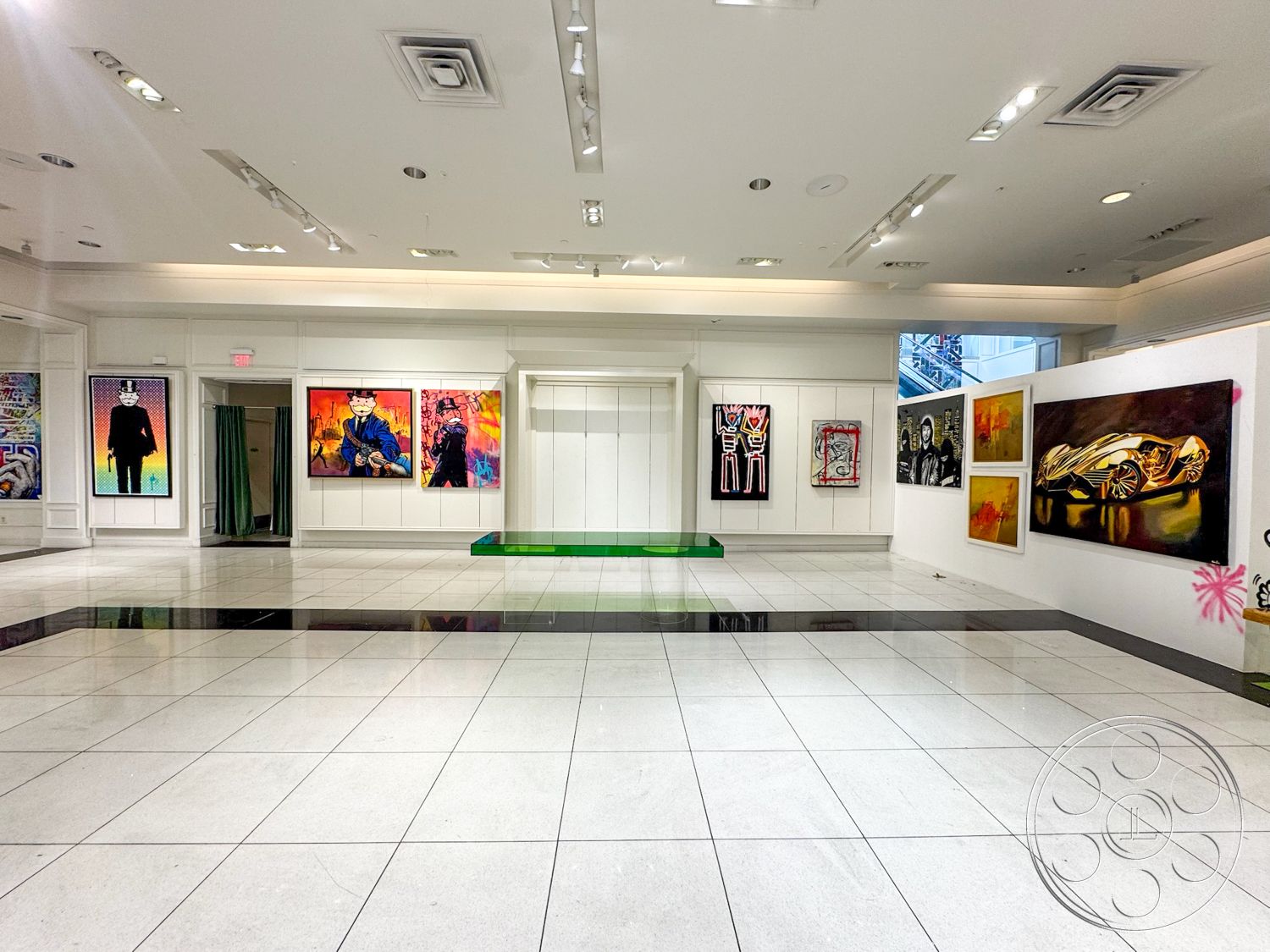 Beverly Gallery - neutral color palette, interior space, glass windows, white wainscoting, polished tile flooring, exposed ceiling lights, large format white floor tiles, black accent tile, gallery wall with framed artwork, rectangular display platform, curtained entrance, bright, contemporary design, open gallery layout, modern art exhibits
