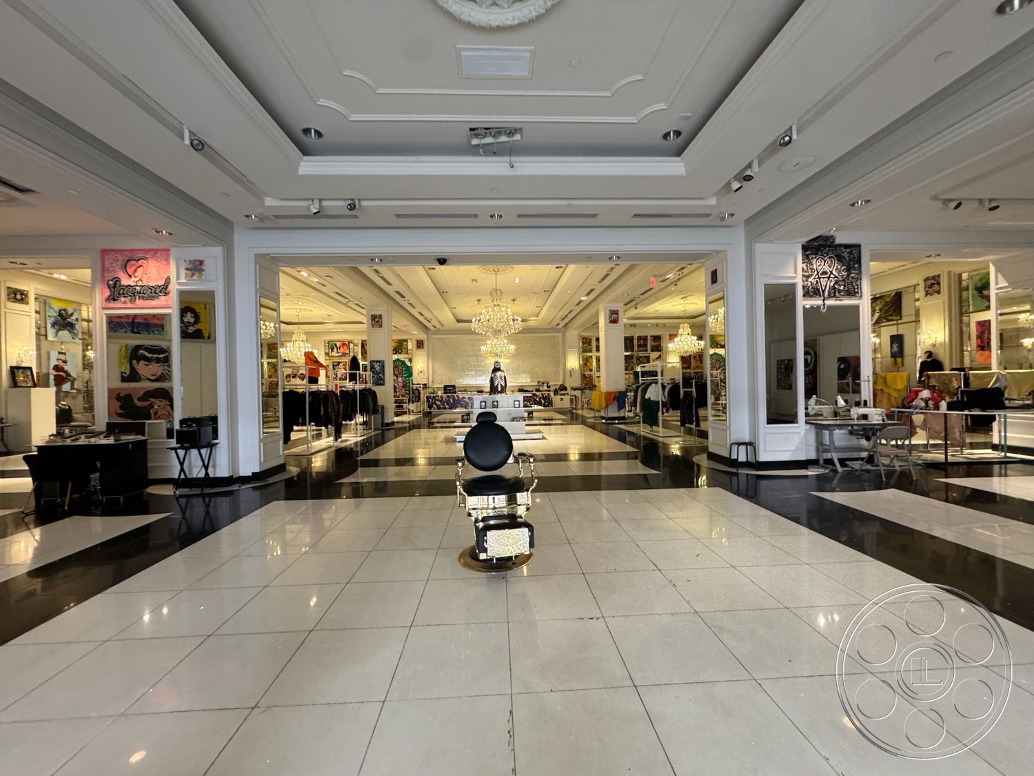 Beverly Gallery - chandelier lighting, polished marble flooring, stylish seating area, exposed structural elements, ambient lighting fixtures, coffered ceiling details, contemporary art gallery, modern retail space, black and white tile pattern, illuminated art display walls, large glass storefront, decorative wall murals, high ceiling open layout