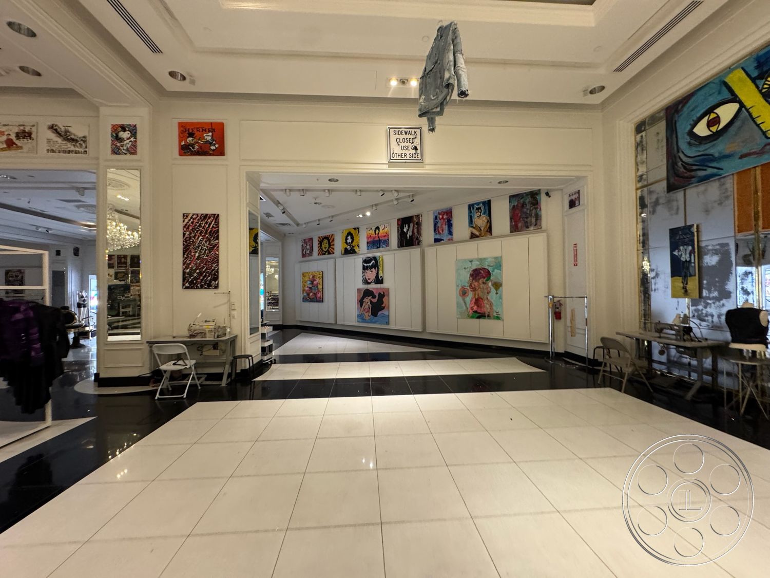 Beverly Gallery - coffered ceiling, textured wall art, open floor plan, polished marble flooring, large chandeliers, white painted walls, modern display tables, black and white tile floor design, exhibition art wall, glass-front display cabinets, gallery-style lighting