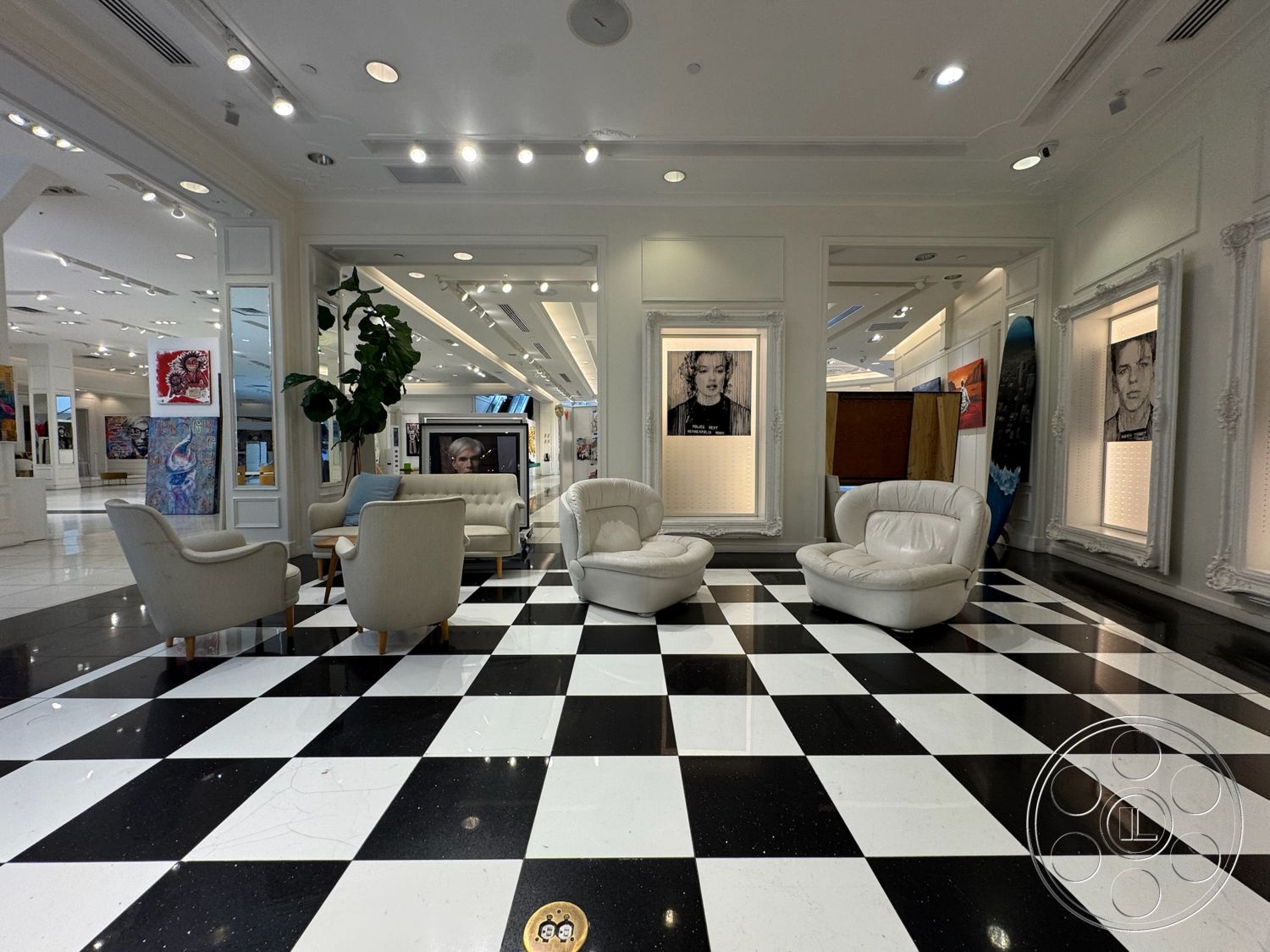 Beverly Gallery - textured white wall finish, exposed ceiling with recessed lighting, modern framed artwork, black and white checkered marble flooring, luxurious white leather lounge chairs, decorative wall-mounted artwork displays, luxurious contemporary design, spacious art gallery layout, indoor potted greenery