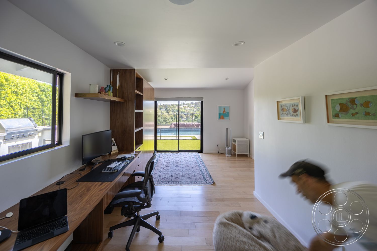 Modern 390 - hardwood flooring, decorative area rug, open layout, glass sliding doors, minimalist room design, large windows with garden view, textured white walls, walnut wood desk, contemporary shelving unit