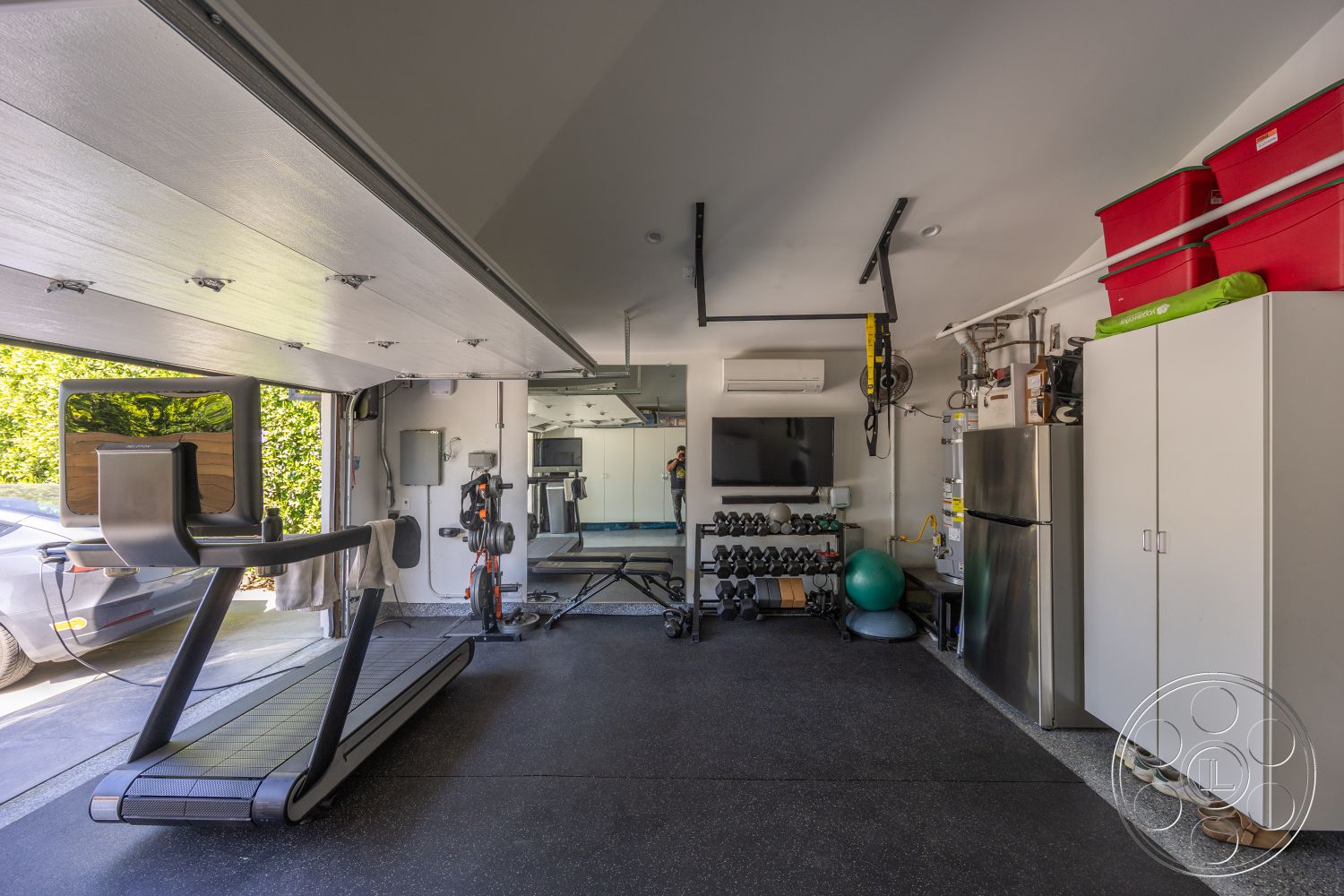 Modern 390 - rubber flooring, weightlifting equipment, metal storage cabinets, organized storage solutions, concrete wall structure, open garage layout, interior gym garage, garage with overhead door, wall-mounted exercise equipment, treadmill with display screen, leisure fitness area, large floor-to-ceiling mirror, suspended ceiling with lights