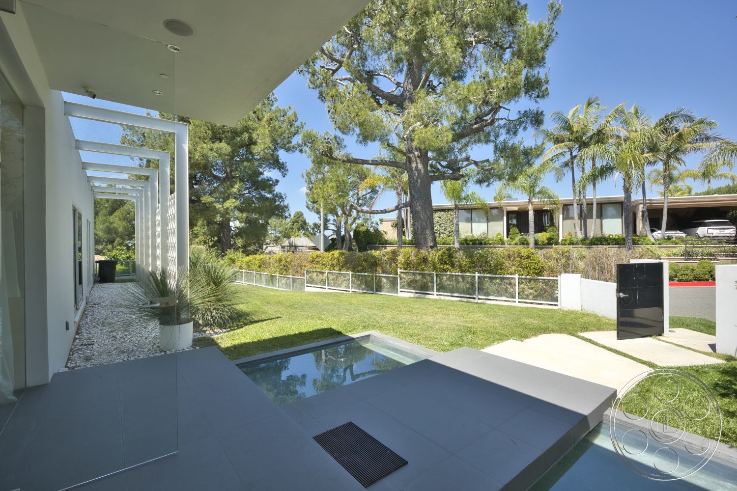 Modern 525 - large windows, exterior, landscaped garden, white stucco walls, palm trees, sliding glass doors, concrete pathway, metal fence, planter boxes, outdoor living space, modern architectural style, lawn area, rectangular pool, flat roof design, pergola with slatted roof, stone pool decking