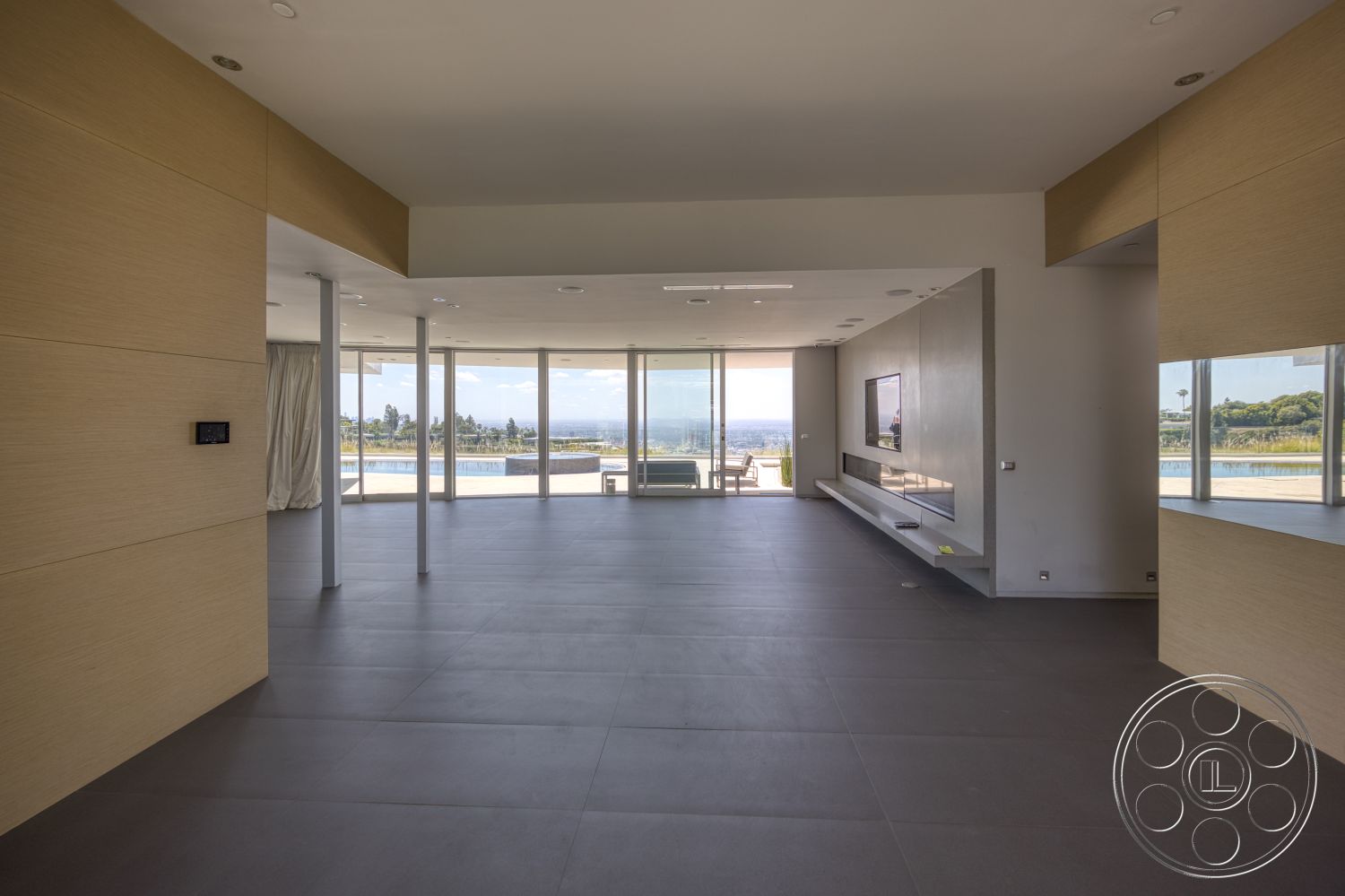 Modern 525 - high ceilings, natural light, open floor plan, seamless indoor-outdoor transition, floor-to-ceiling windows, smooth concrete flooring, modern minimalist design, built-in entertainment unit, light wood panel accent walls