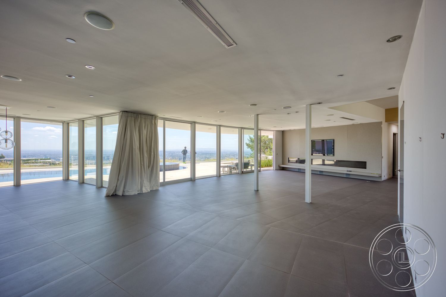 Modern 525 - recessed lighting, landscaped garden, minimalist design, open floor plan, modern light fixtures, exposed ceiling, ocean view, mountain backdrop, large floor-to-ceiling windows, white painted walls, outdoor patio area, light gray tile flooring, concrete support columns, built-in media console, curtains for window treatment