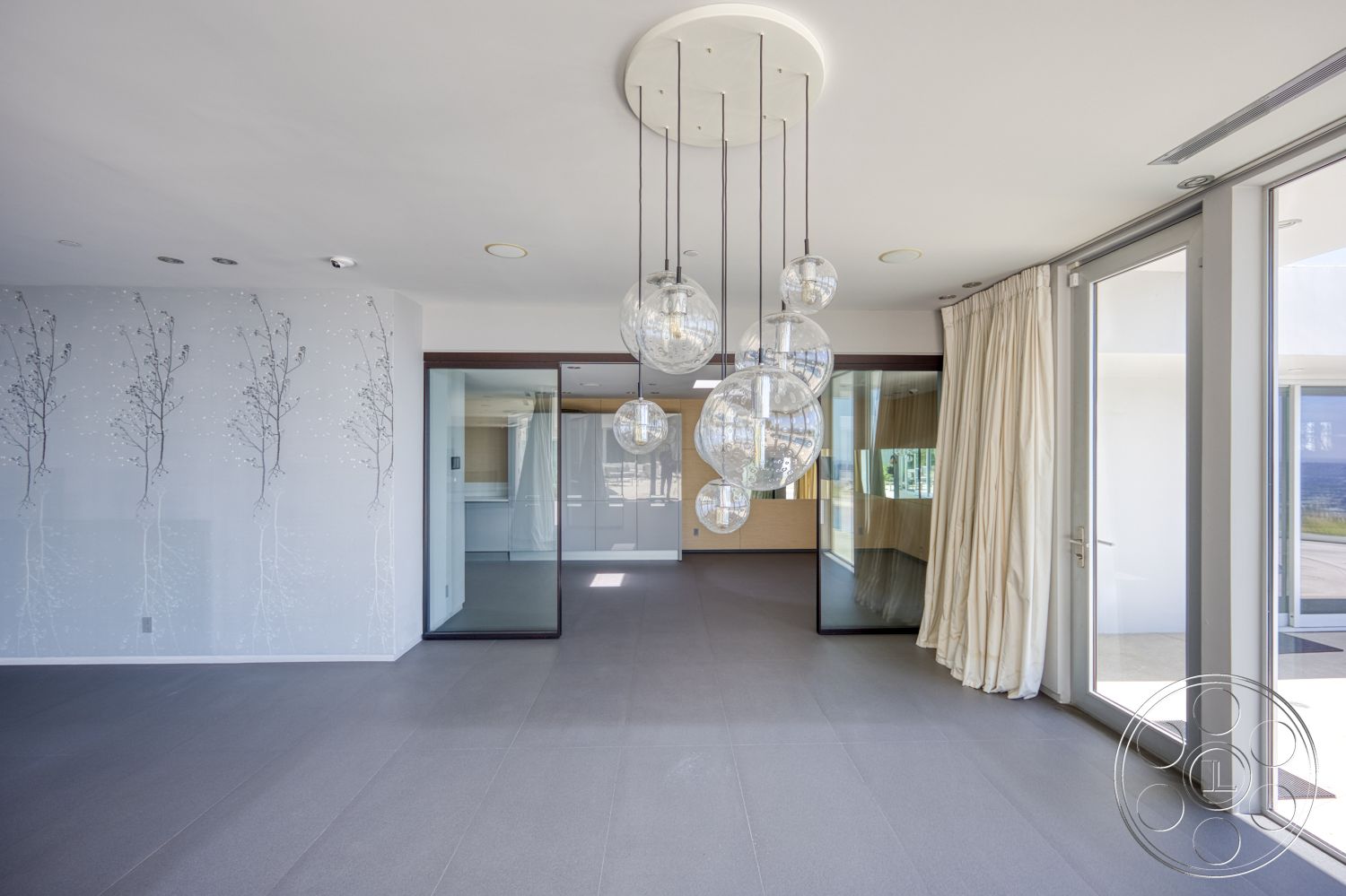 Modern 525 - open floor plan, minimalist design elements, modern architectural style, floor-to-ceiling glass doors, light grey tile flooring, glass pendant lighting fixtures, textured wall treatment with floral design, neutral-colored drapes