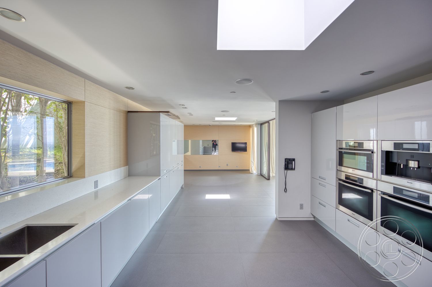 Modern 525 - open concept layout, floor-to-ceiling windows, gray tile flooring, textured wall paneling, minimalist aesthetics, contemporary kitchen design, built-in kitchen appliances, quartz kitchen countertops, skylight ceiling, sleek white cabinetry, flush ceiling lighting