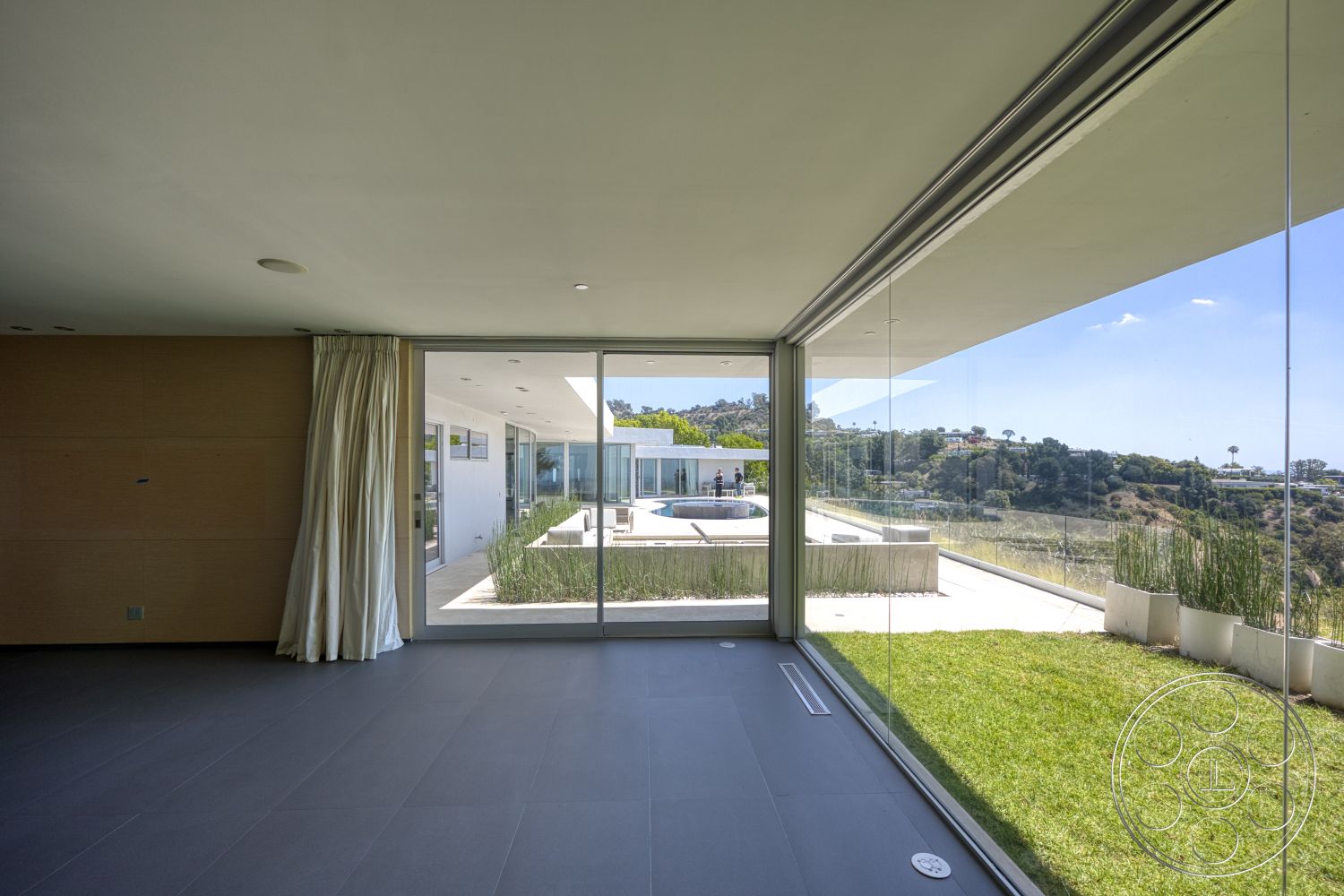 Modern 525 - modern architecture, minimalist design, sliding glass door, gray tile flooring, large floor-to-ceiling windows, hillside location, open-plan layout, lush green landscaping, white painted walls, concrete patio floor