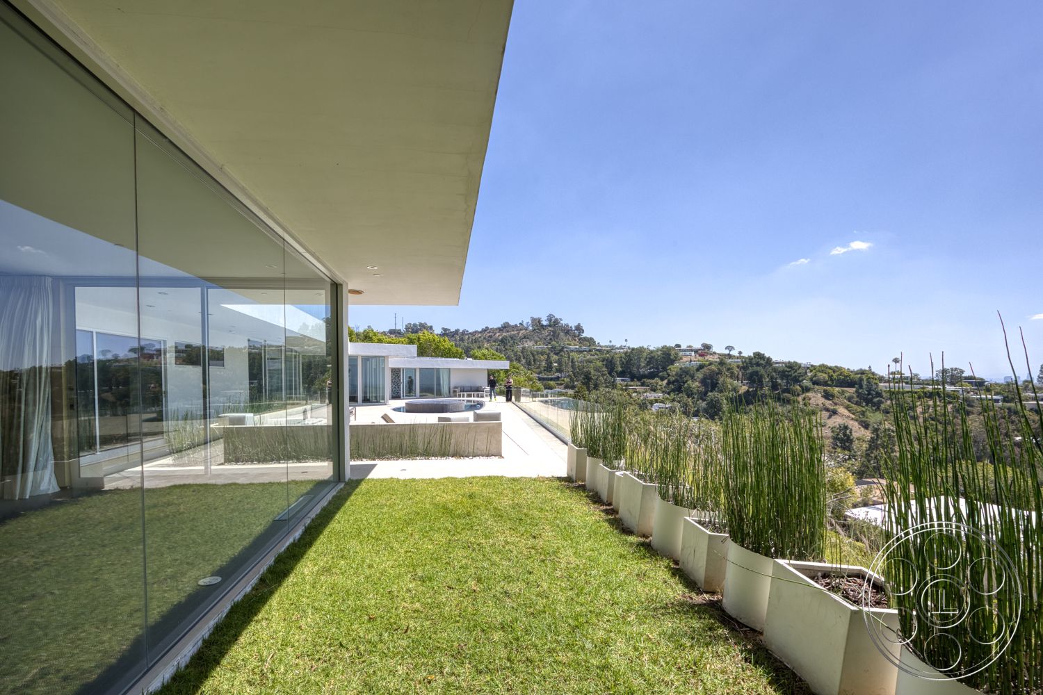 Modern 525 - exterior, flat roof, modern architectural style, outdoor entertainment area, mountain view setting, concrete patio flooring, glass wall panels, minimalist design features, landscape garden with ornamental grass