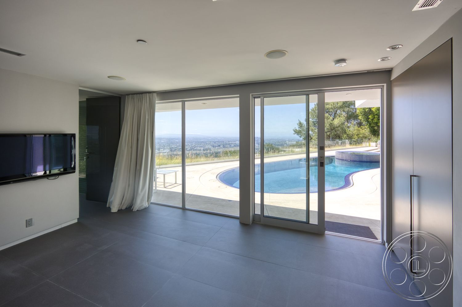 Modern 525 - glass sliding doors, floor-to-ceiling windows, open living space, infinity pool, concrete pool deck, mountain view setting, light gray ceramic floor tiles, minimalist wall panels