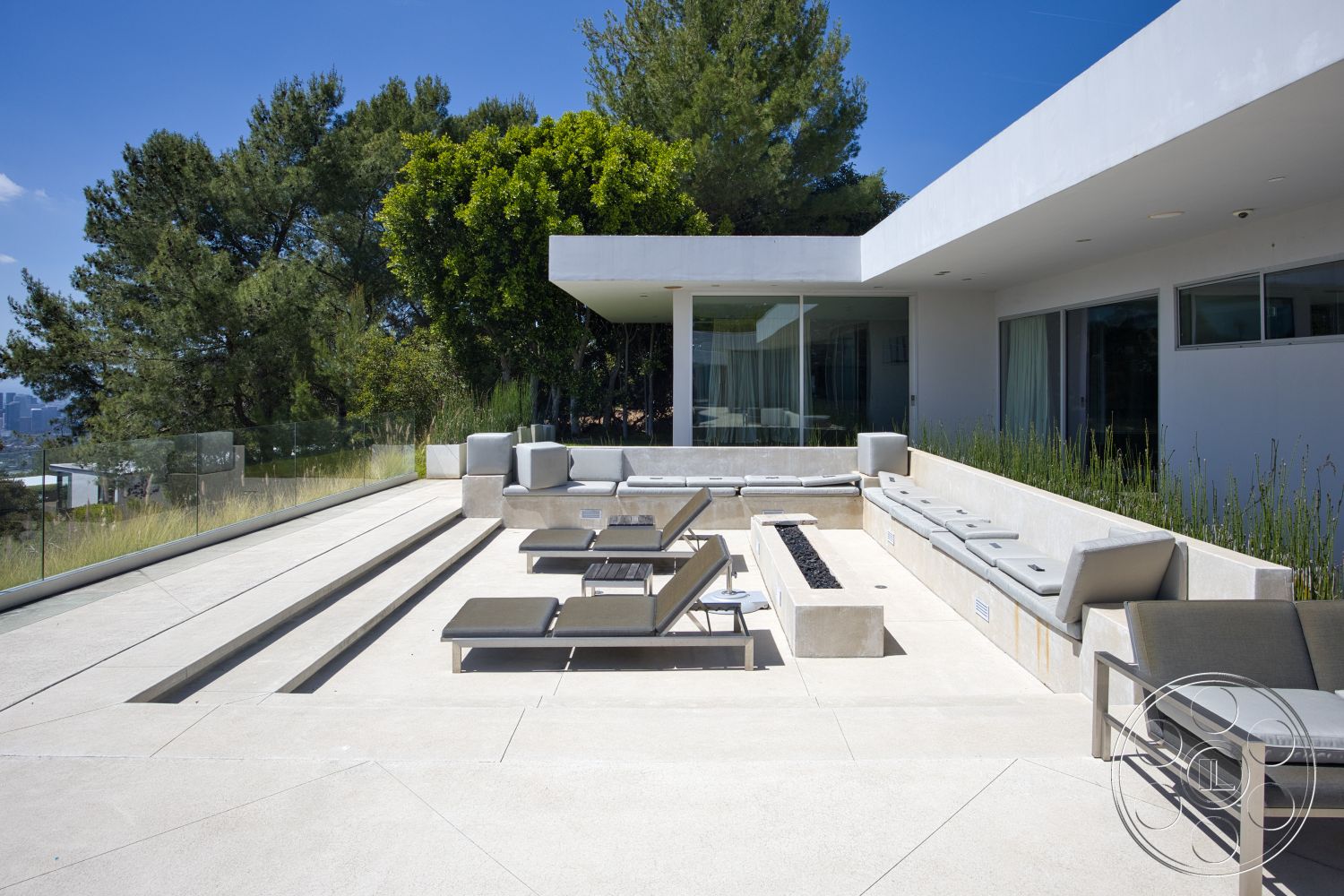 Modern 525 - exterior, glass railing, surrounding greenery, floor-to-ceiling windows, modern architectural style, horizontal landscaping, concrete patio flooring, stainless steel outdoor furniture, rectangular fire pit, mountain skyline view, concrete seating wall