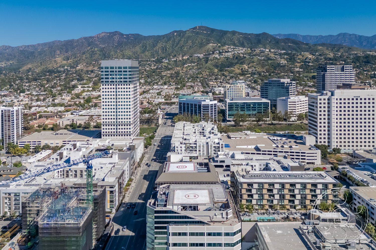 Rooftop-52 - exterior, city skyline view, asphalt road, surrounding mountain landscape, steel structural framework, concrete urban buildings, glass curtain wall façade, modern high-rise architecture, flat rooftop terraces, commercial office buildings