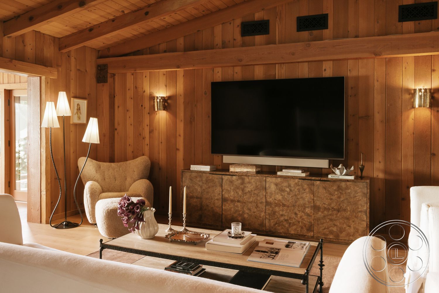 Modern-Farmhouse 20 - hardwood flooring, modern lighting fixtures, plastered walls, decorative wall sconces, exposed wood ceiling beams, open floor plan living area, exterior wood paneling, upholstered accent chair, contemporary television unit, textured coffee table