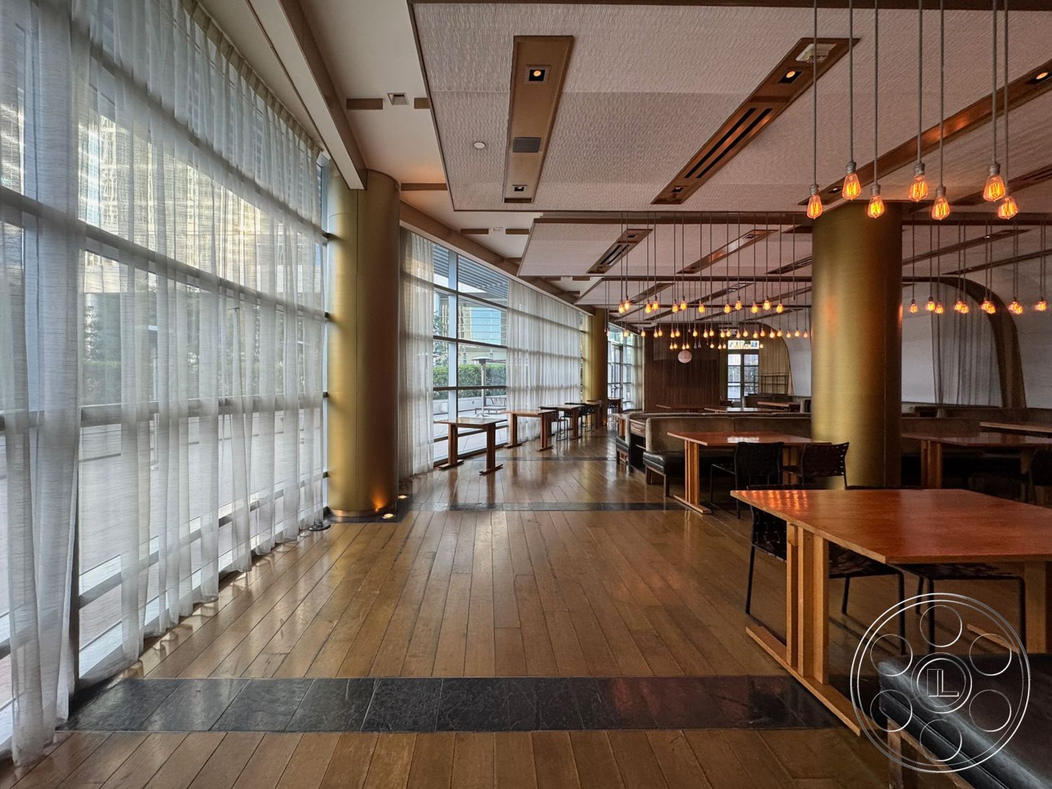 Ave Of The Stars - open floor plan, linear pendant lighting, textured ceiling panels, wooden dining tables, exposed ceiling ductwork, hardwood restaurant flooring, black stone floor inlay, curtained glass wall, modern booth seating, gold column accents, interior restaurant space