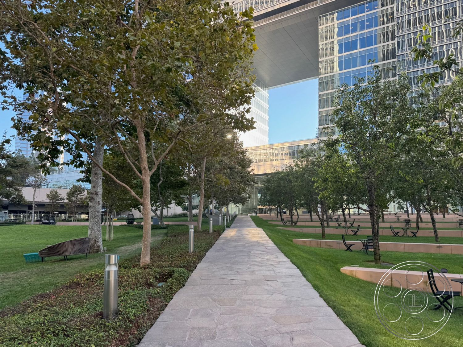 Ave Of The Stars - exterior, landscaped garden, mature trees, stone pathway, green lawn, wooden benches, glass exterior walls, urban park setting, concrete seating areas, steel light posts, office building façade, reflected skyline, open pedestrian walkway