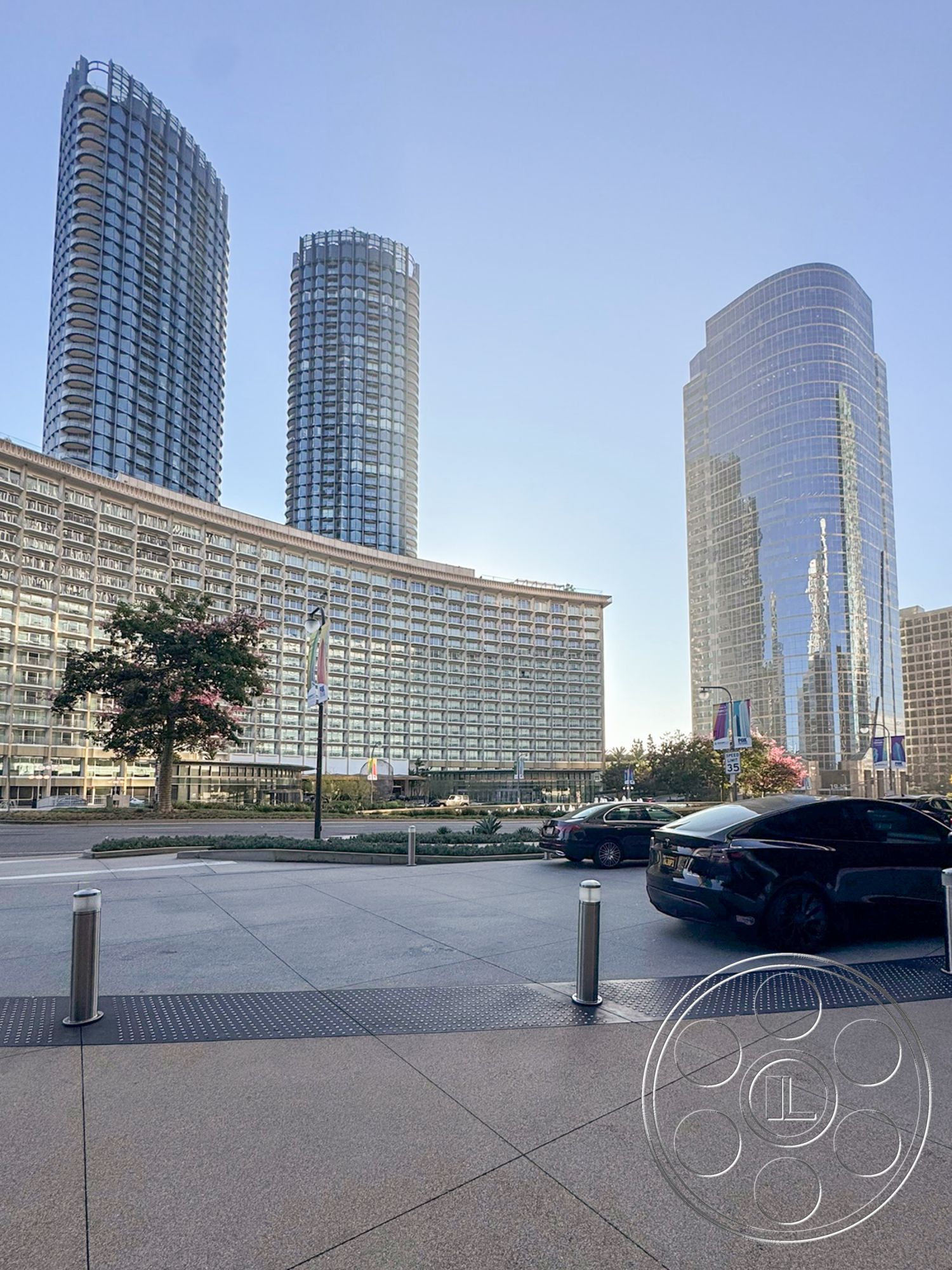 Ave Of The Stars - exterior, parking area, concrete planters, polished stone plaza flooring, commercial building facade, reflective glass surfaces, steel structural framework, modern urban skyline, vertical glass panels, glass curtain wall towers, curved building shapes, landscaped urban environment, multi-story residential tower, metro city setting, public area with street access