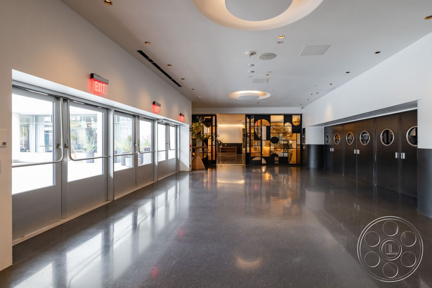Sunset Campus - neutral color palette, recessed lighting, minimalist design, open floor plan, polished concrete flooring, sliding glass doors, floor-to-ceiling windows, black metal accents, suspended ceiling, geometric wall decor, modern exit signage, industrial-style design