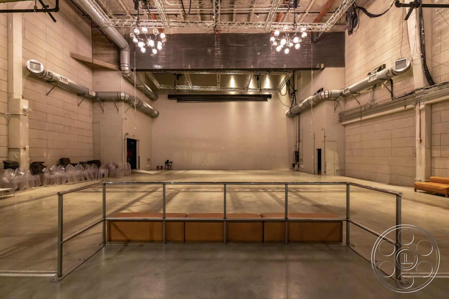 Sunset Campus - high ceilings, neutral color palette, exterior, minimalist design, open floor plan, concrete floor, exposed concrete walls, metal railing, exposed ductwork, pendant lighting fixtures, industrial ceiling, flexible event space