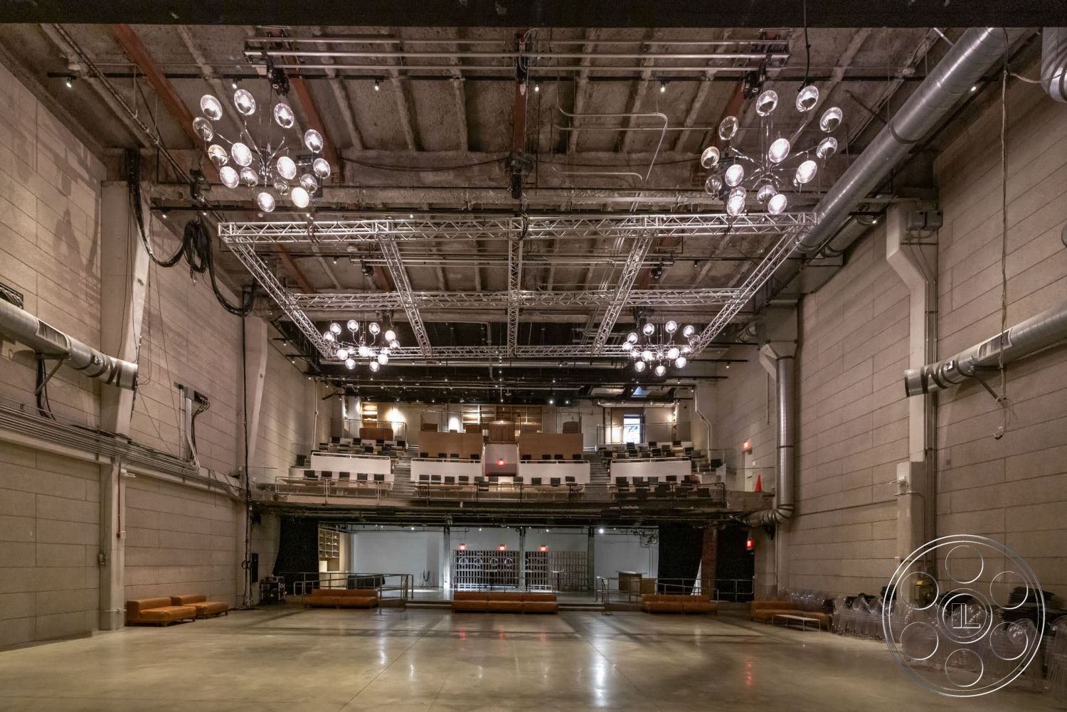 Sunset Campus - polished concrete flooring, interior space, concrete walls, industrial design elements, exposed concrete ceiling, wooden benches, open performance area, steel lighting fixtures, suspended ceiling trusses, mechanical ductwork, theater seating area, floor-to-ceiling stage area