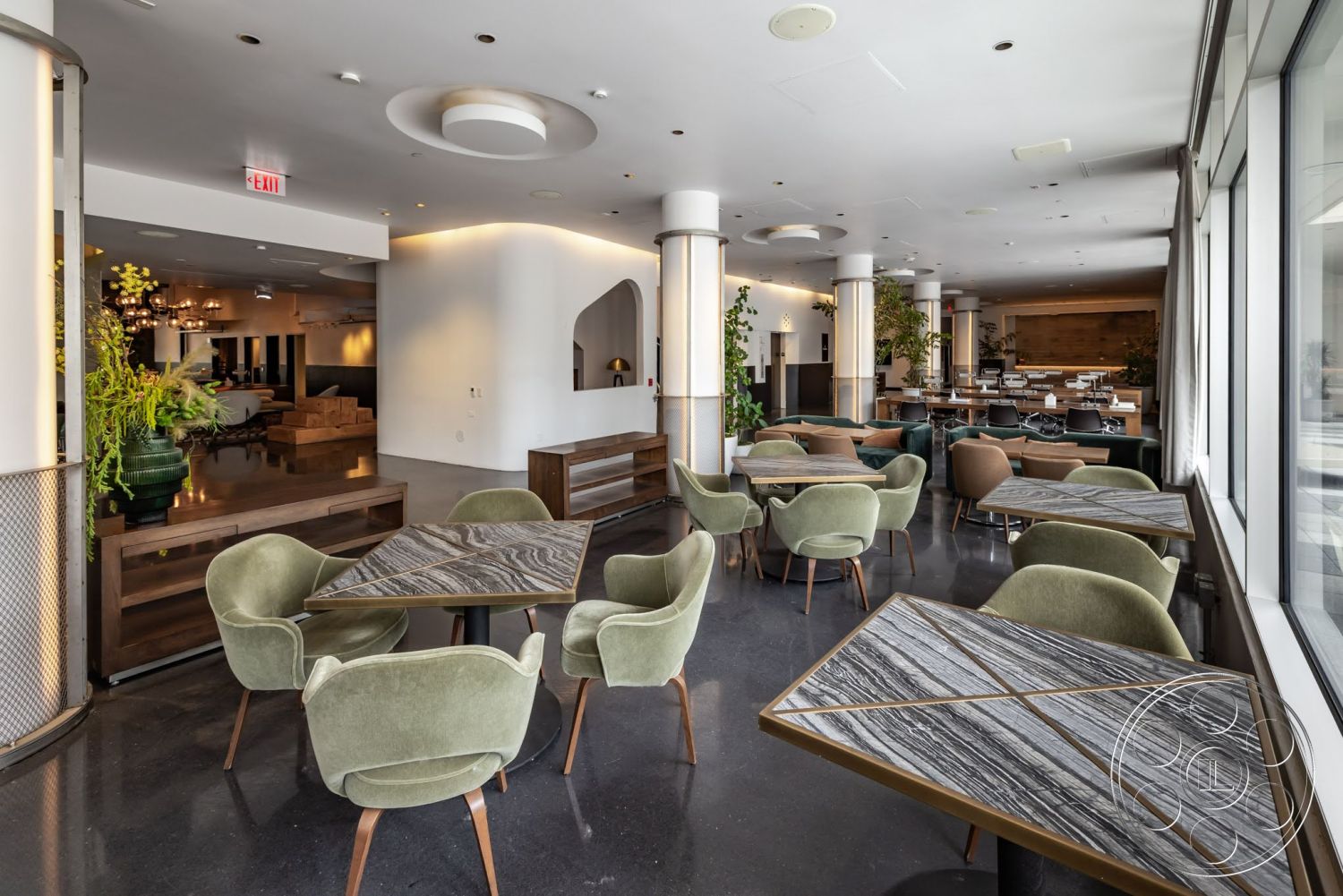 Sunset Campus - neutral color palette, polished concrete flooring, minimalist design elements, metal accents, floor-to-ceiling windows, textured wall finishes, soft lighting fixtures, decorative wall panels, open dining area, round ceiling lights, modern dining space, green velvet armchairs, geometric-shaped tables, wooden seating furniture, planter greenery
