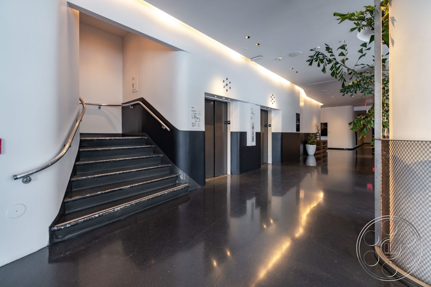 Sunset Campus - floor-to-ceiling windows, white plaster walls, black accent walls, indoor plant decor, curved staircase, minimalist architectural design, stainless steel handrail, polished black concrete flooring, modern elevator entrances, indirect ceiling lighting