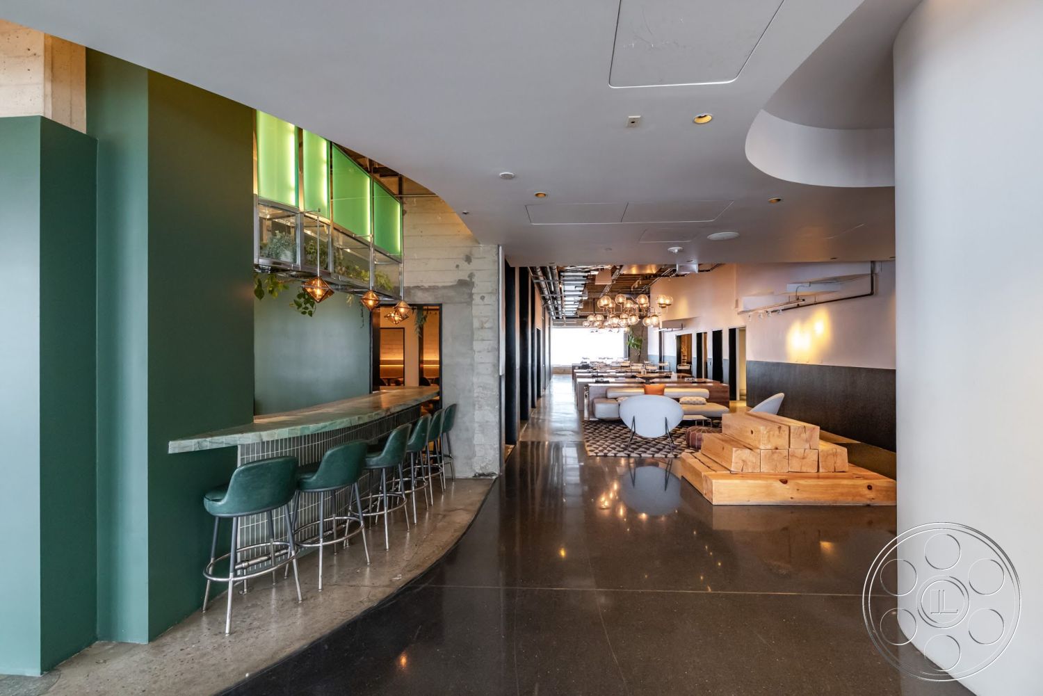 Sunset Campus - minimalist design, modern interior, exposed concrete walls, metal bar stools, hanging pendant lights, green accent wall, glass display cabinets, open dining area, wood steps, marble bar countertop, restaurant setting, polished black tile flooring
