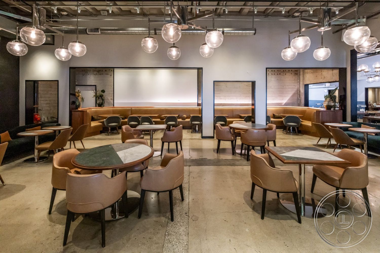 Sunset Campus - polished concrete flooring, modern pendant lighting, exposed concrete walls, open dining area, contemporary interior design, wood beam ceiling, urban restaurant setting, round tables with marble tops, upholstered leather dining chairs, cabinetry with wood finish