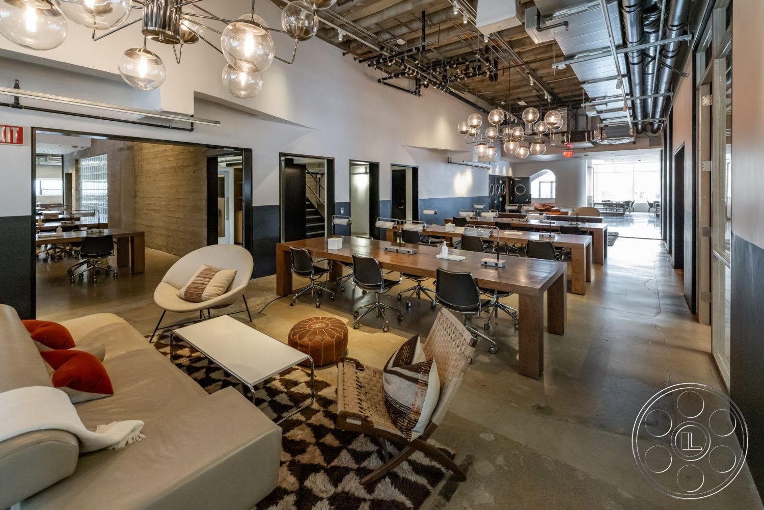 Sunset Campus - polished concrete floor, concrete flooring, modern coffee table, dark wood paneling, exposed ceiling beams, glass partition walls, urban office environment, acoustic tile ceiling, open workspace layout, interior workspace, industrial style lighting fixtures, retro pendant lighting, black metal office chairs, furniture-grade wood desks, modern armchair with white upholstery