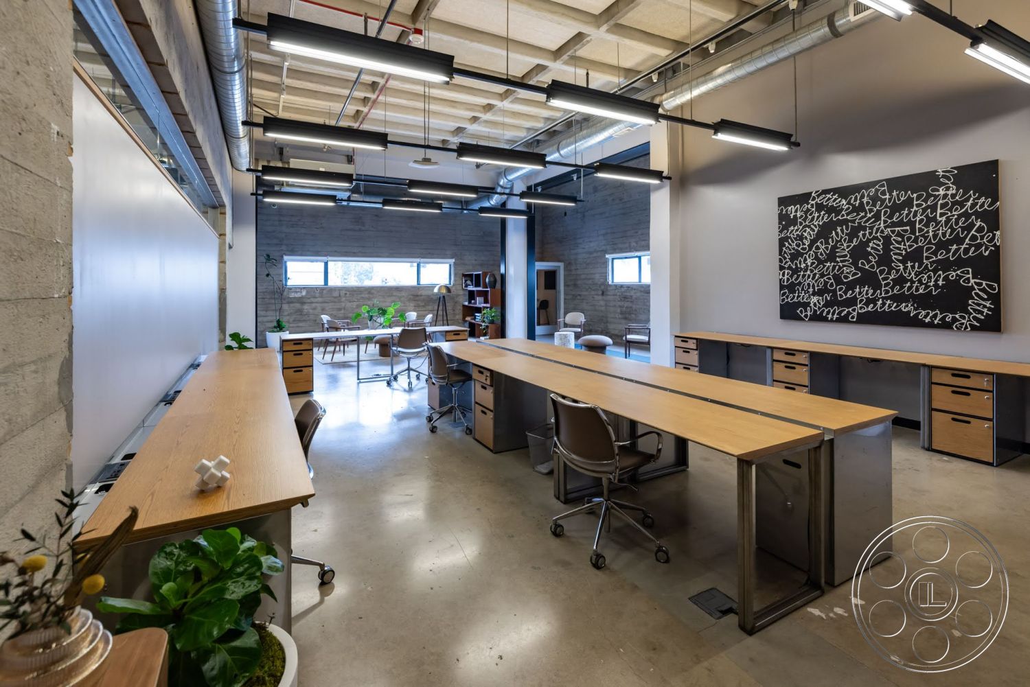 Sunset Campus - minimalist decor, large windows, open floor plan, polished concrete flooring, creative workspace, modern lighting fixtures, exposed concrete walls, collaborative office area, wooden work desks, metal desk supports, industrial style ceiling beams, plants as interior accents