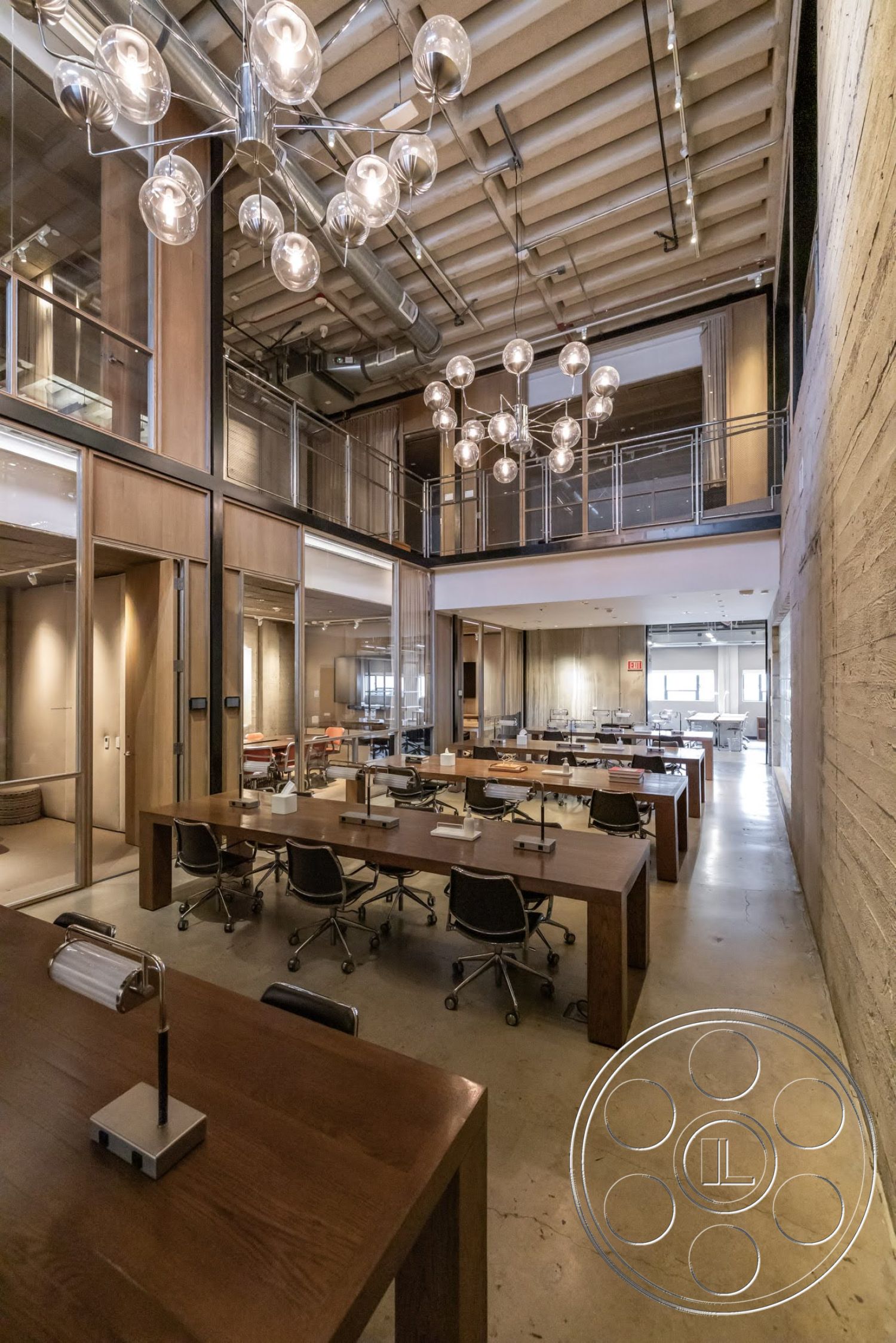 Sunset Campus - neutral color palette, polished concrete flooring, modern pendant lighting, exposed concrete walls, open office layout, ergonomic office chairs, wood beam ceiling, high ceiling space, urban office environment, industrial style decor, large glass partition walls, executive desks with wooden surfaces