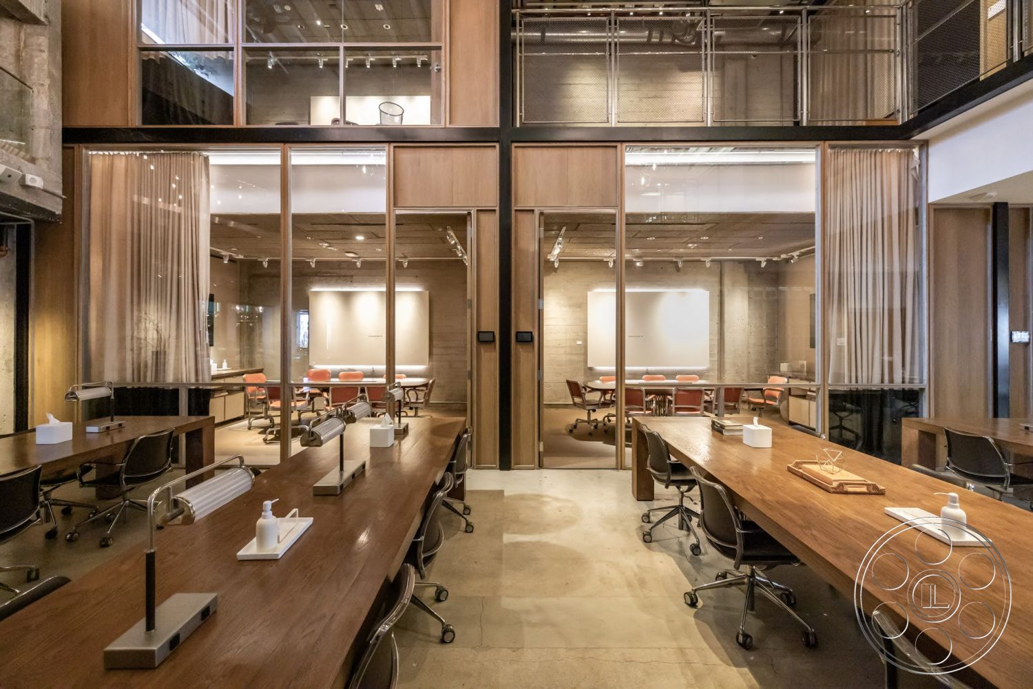 Sunset Campus - concrete floor, exposed concrete walls, industrial lighting fixtures, textured ceiling, glass partition walls, modern office design, interior office space, metal office chairs, wood conference table, wood paneled wall accent, curtain room divider