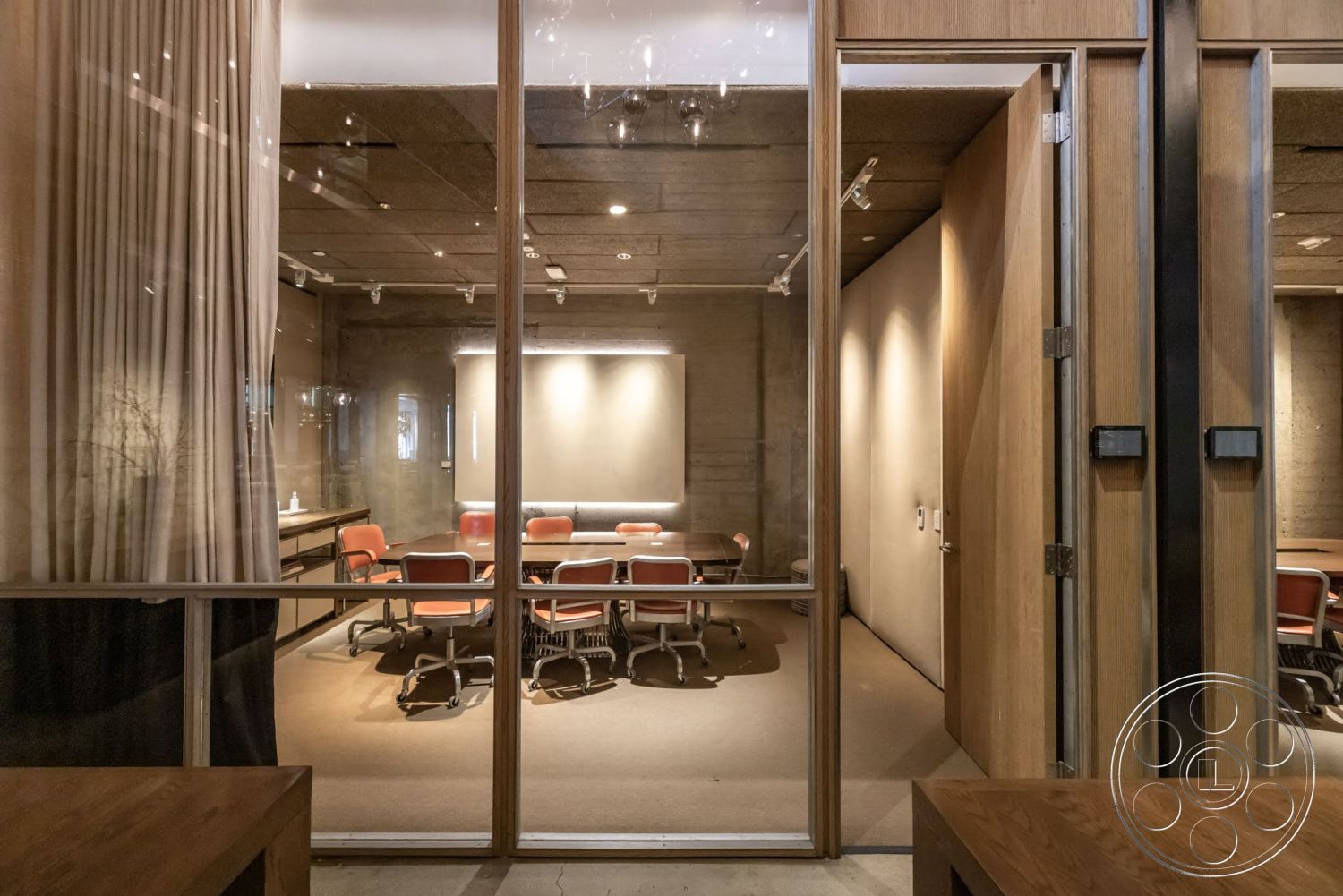 Sunset Campus - neutral color palette, open layout, modern design, exposed concrete walls, high ceiling, carpet flooring, conference room, architectural lighting, glass partition walls, textured ceiling tiles, metal chair legs, wood panel doors