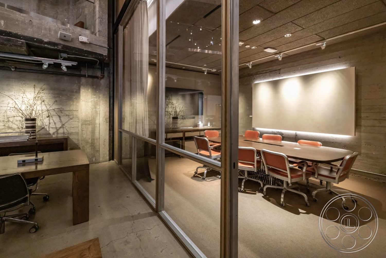 Sunset Campus - minimalist decor, concrete flooring, exposed concrete walls, industrial style, task lighting, conference room, recessed ceiling lights, glass partition walls, modern office layout, textured ceiling panels, mid-century modern chairs, soft beige color palette, wood meeting table