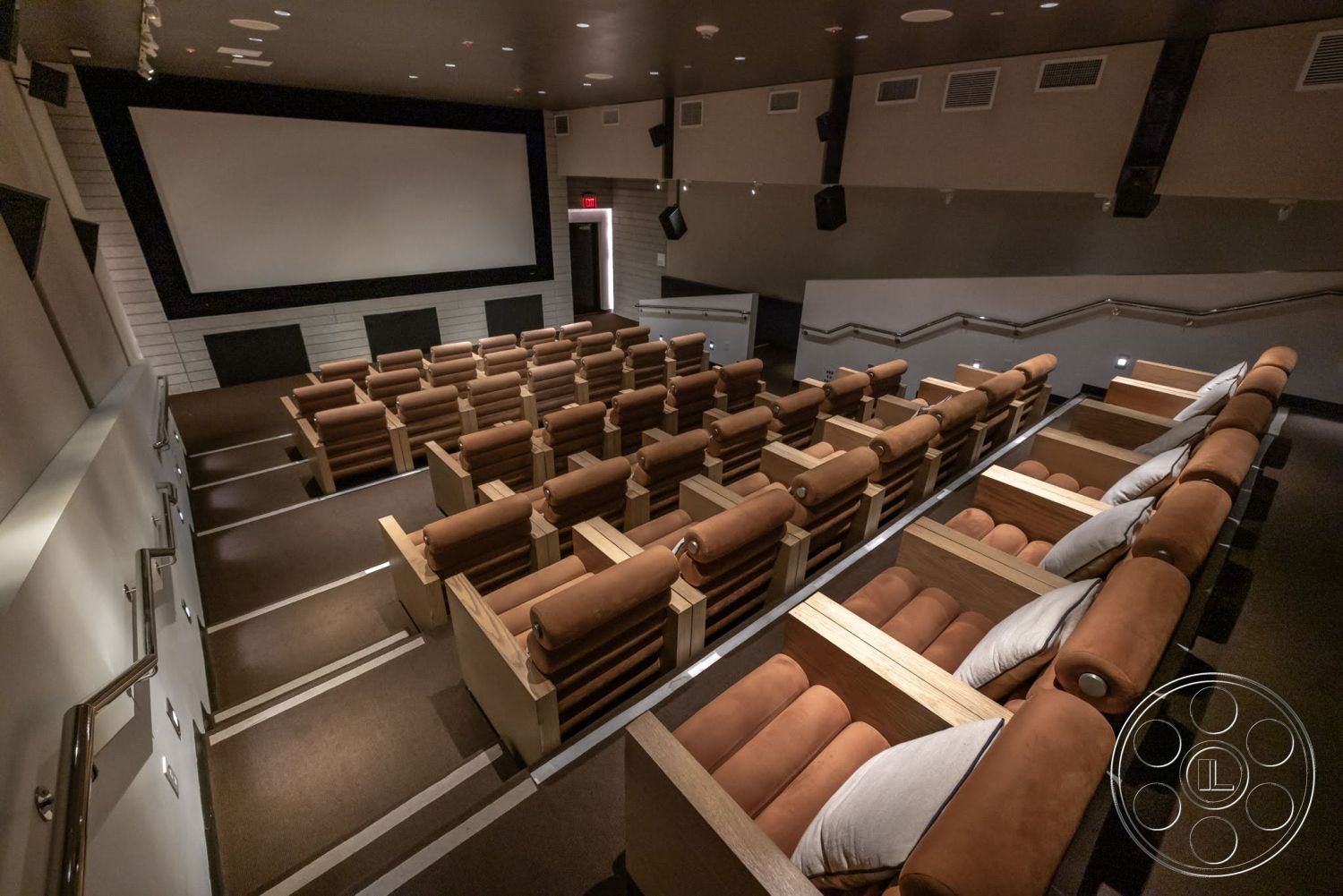 Sunset Campus - carpeted flooring, dark wood paneling, acoustic ceiling panels, multiple seating rows, home theater room, reclining leather seats, screened projection area, high-tech sound equipment, raised seating arrangement, cinematic ambiance