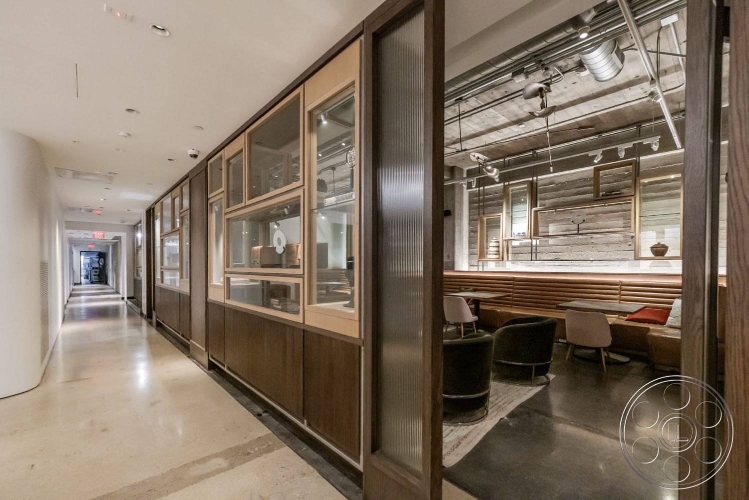 Sunset Campus - dark wood cabinetry, polished concrete floor, contemporary furniture, open layout, wood paneling, modern lounge area, glass partition walls, recessed lighting fixtures, interior hallway, exposed ductwork ceiling, horizontal wood slat accent wall