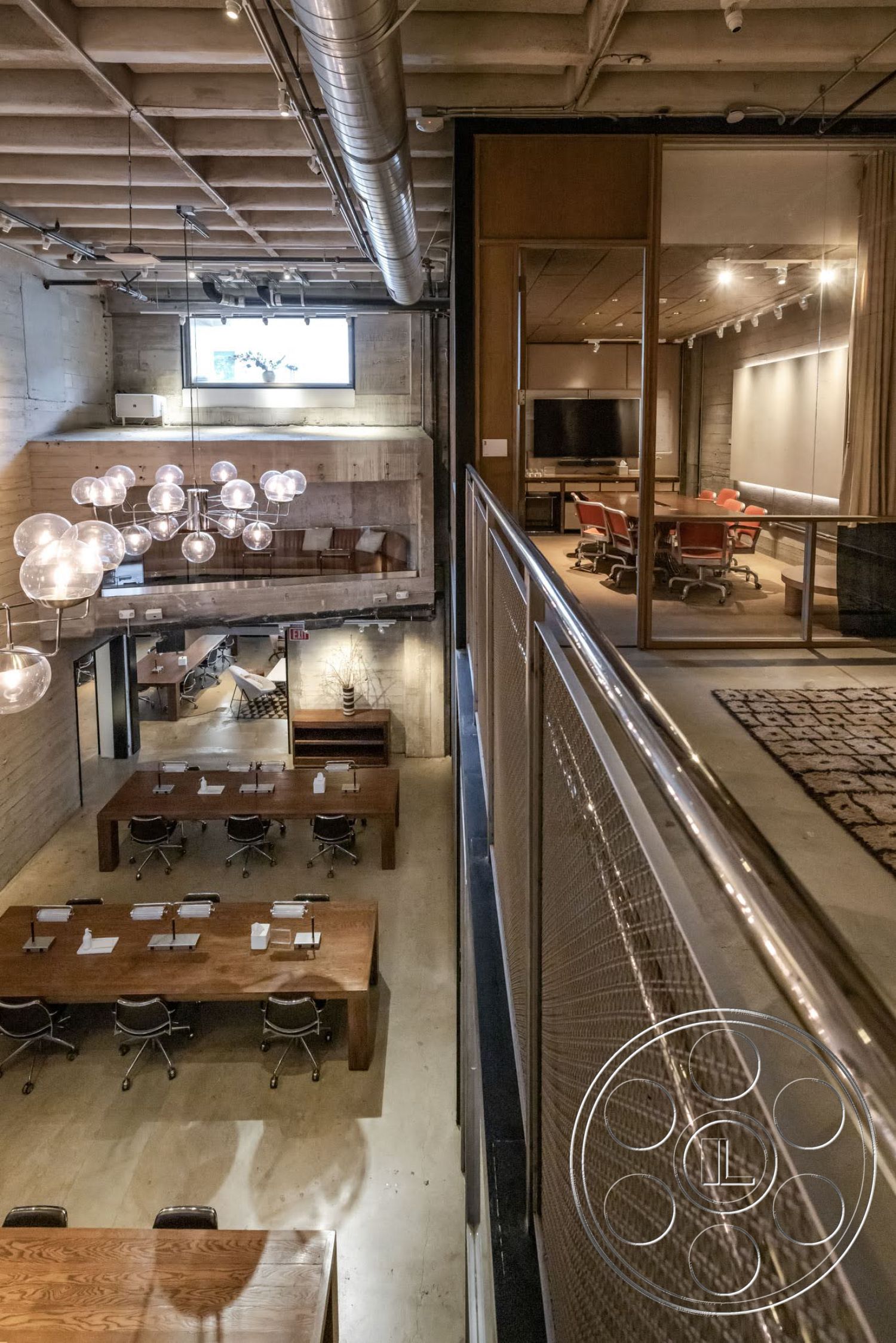 Sunset Campus - high ceilings, modern design, open floor plan, polished concrete flooring, exposed concrete walls, metal railing, workstation area, wide windows, urban office space, industrial pendant lighting, metal chair legs, wood conference tables, glass conference room partitions