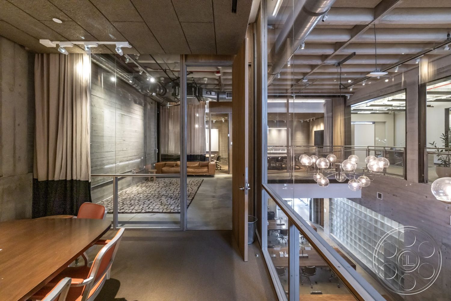 Sunset Campus - open floor plan, concrete walls, upholstered chairs, textured wall treatment, concrete ceiling, glazed windows, metal ductwork, glass partition walls, wood beam ceiling, modern office design, wood conference table, pendant light fixtures