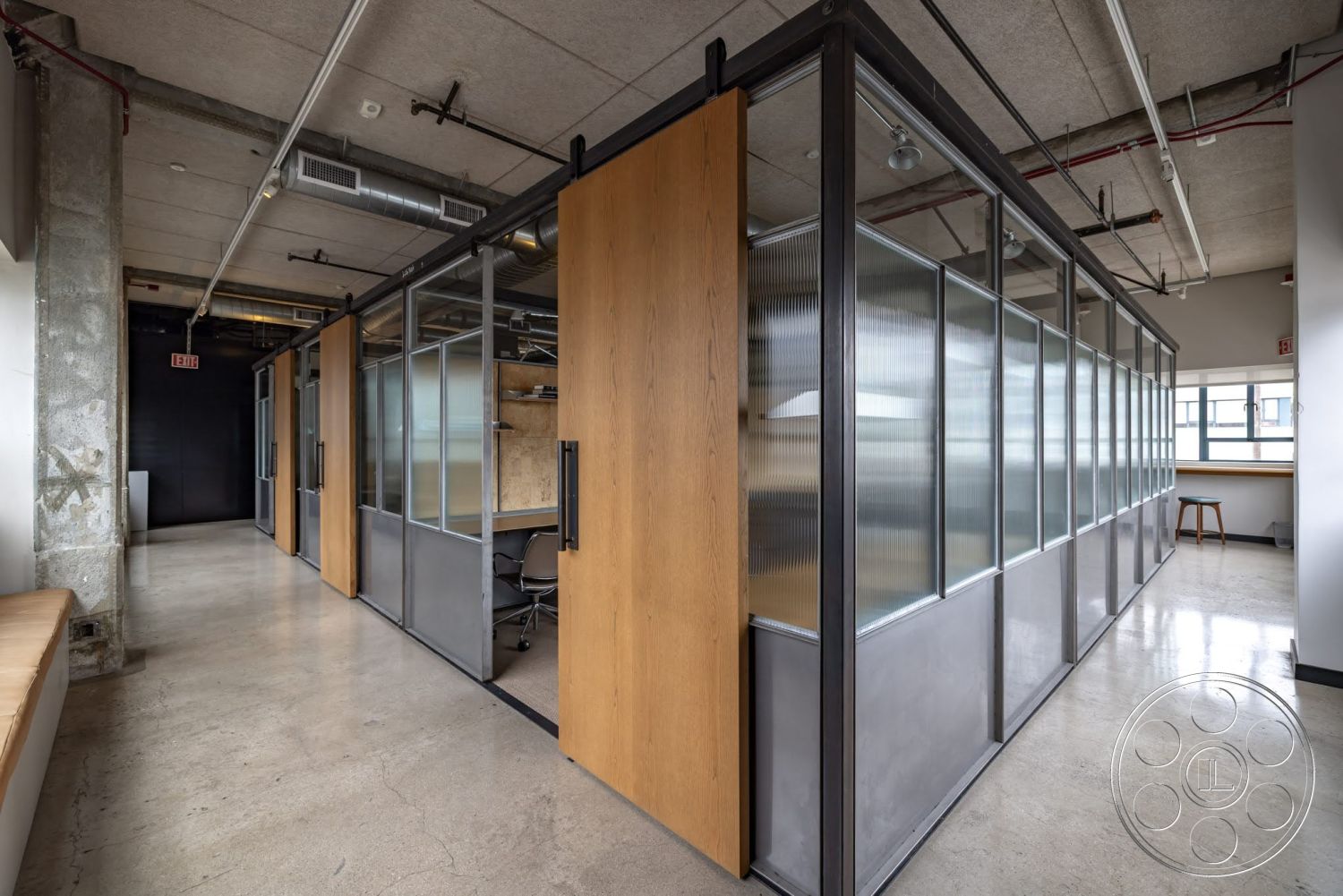 Sunset Campus - concrete floor, exposed concrete walls, industrial style, workspace area, open office layout, glass partition walls, wood sliding office doors, metal framing details