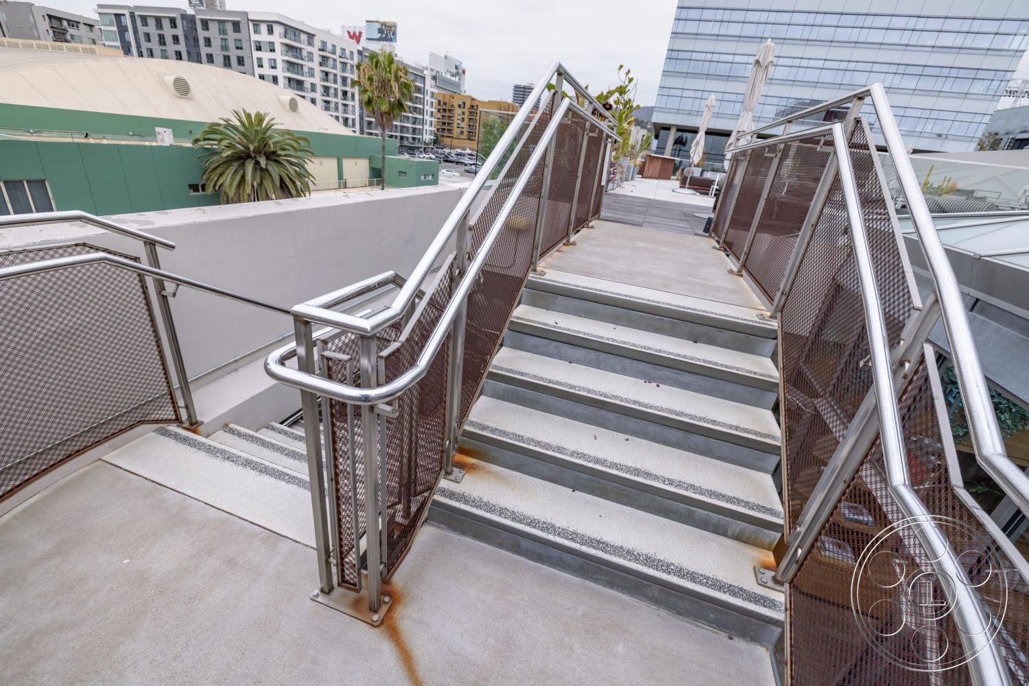 Sunset Campus - exterior, palm trees, metal railing, urban setting, concrete stairs, modern architectural style, concrete landing, perforated metal panels, two-story urban building view