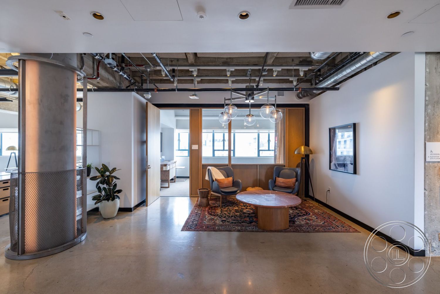Sunset Campus - neutral color palette, decorative area rug, open floor plan, wood paneling, polished concrete flooring, modern pendant lighting, interior space, exposed concrete walls, floor-to-ceiling windows, glass windows, lounge area, mid-century modern furniture, steel support columns, industrial style design