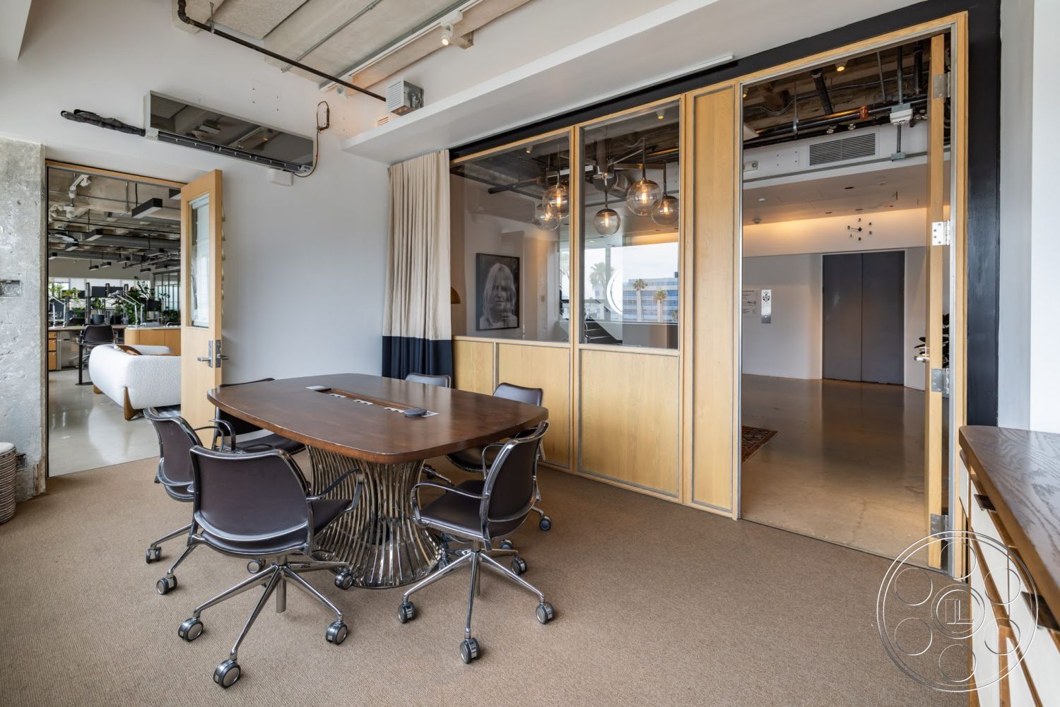 Sunset Campus - neutral color palette, concrete floor, modern pendant lighting, natural wood door, open office layout, glass partition walls, textured carpet flooring, contemporary office design, wood conference table, exposed ceiling ducts, metal base chairs