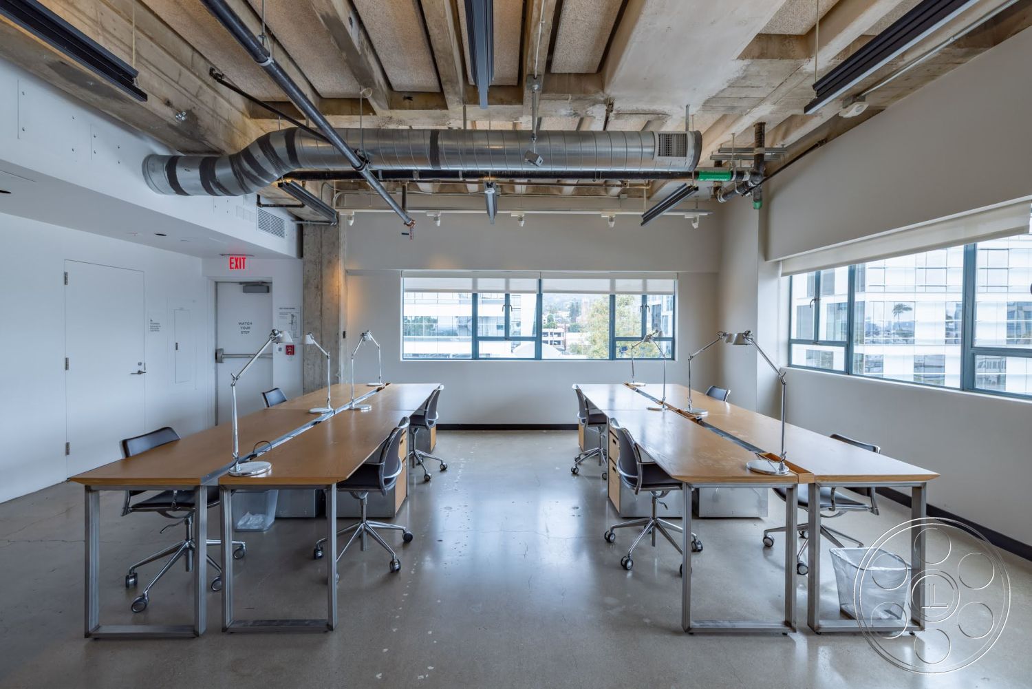 Sunset Campus - fluorescent lighting, collaborative workspace, glass windows, exposed concrete ceiling, metal ductwork, white painted walls, concrete polished floor, wood conference table, industrial style office, chrome office chairs