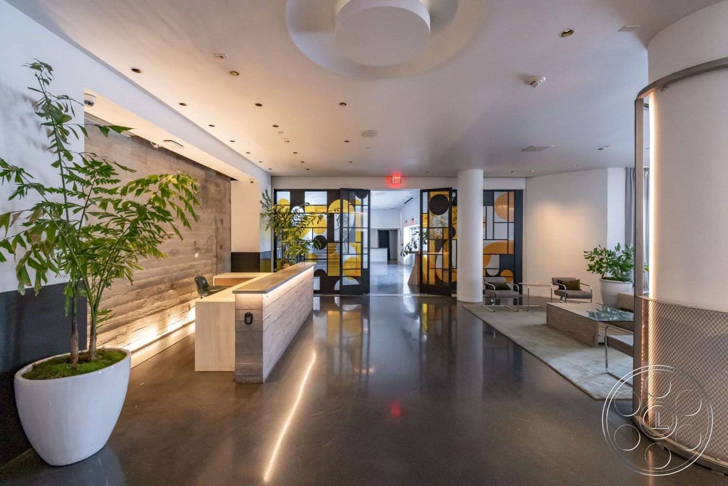 Sunset Campus - polished concrete flooring, urban setting, decorative planters, textured wall paneling, wood accent wall, glass partition walls, interior lobby space, modern reception desk, low-profile seating area, circular ceiling fixtures