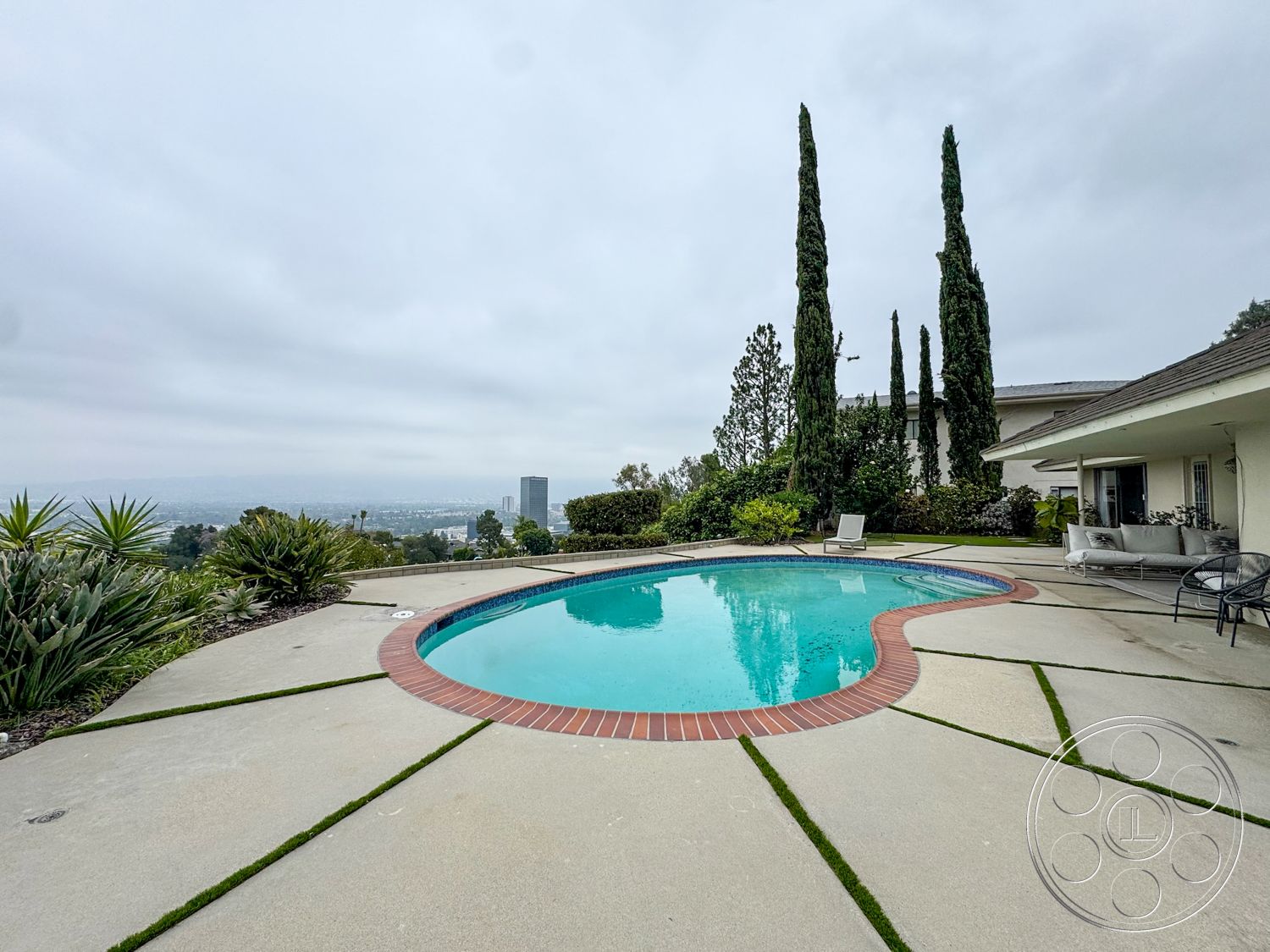Once Upon Hollywood - exterior, landscaped garden, urban skyline view, tall cypress trees, rectangular pool, poolside seating area, concrete pool patio, brick pool border
