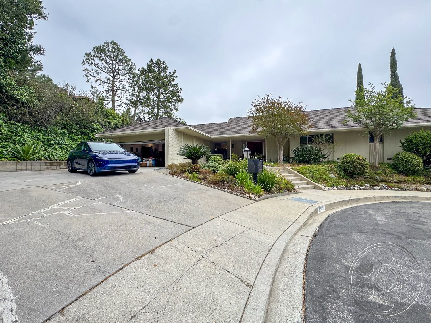 Once Upon Hollywood - large windows, exterior, landscaped garden, decorative shrubs, single-story home, paved walkway, concrete driveway, gabled roof, curved driveway, wooden siding, asphalt road, concrete parking area, stone border, flat roof entryway, steps leading to entry
