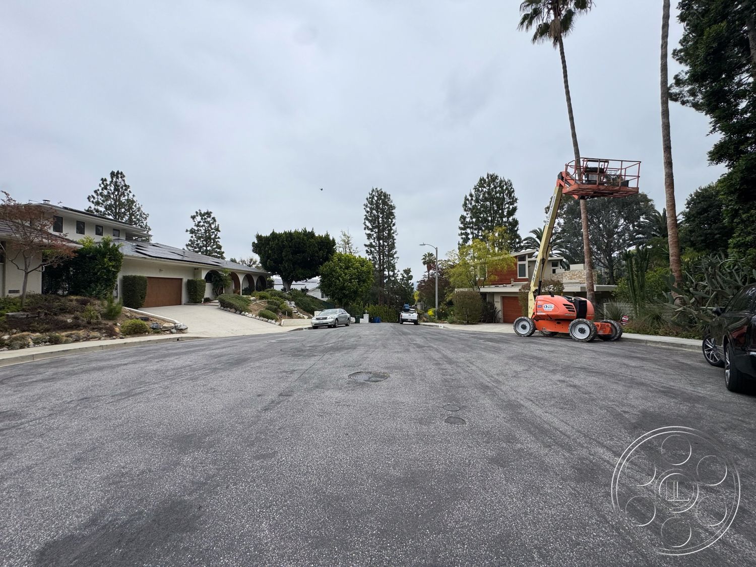 Once Upon Hollywood - palm trees, residential neighborhood, sloped driveway, tiled roof, tree-lined street, open parking space, contemporary architectural style, landscaped garden beds, cloudy sky, paved asphalt road, garden patio area, exterior lighting fixtures, modern house façade, exterior picket fence, decorative retaining wall, maintenance lift