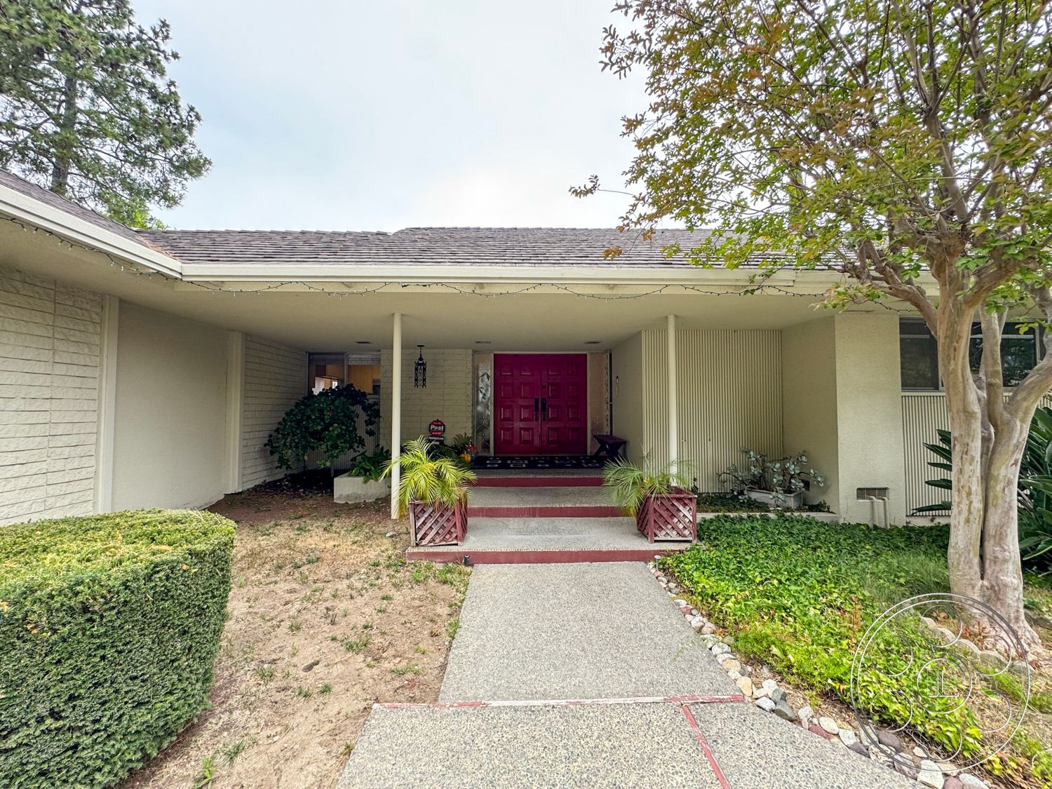 Once Upon Hollywood - exterior, low-maintenance landscaping, flat roof, lawn area, concrete walkway, wooden planters, stone edging, landscaped garden with shrubs, textured exterior walls, decorative hanging lantern, red double front doors, pathway bordered by grass