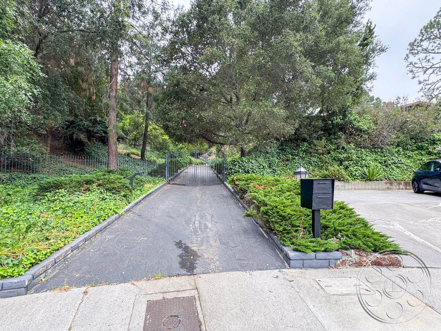 Once Upon Hollywood - exterior, tropical plants, landscaped greenery, suburban setting, mailbox, metal gate, asphalt driveway, stone border edging