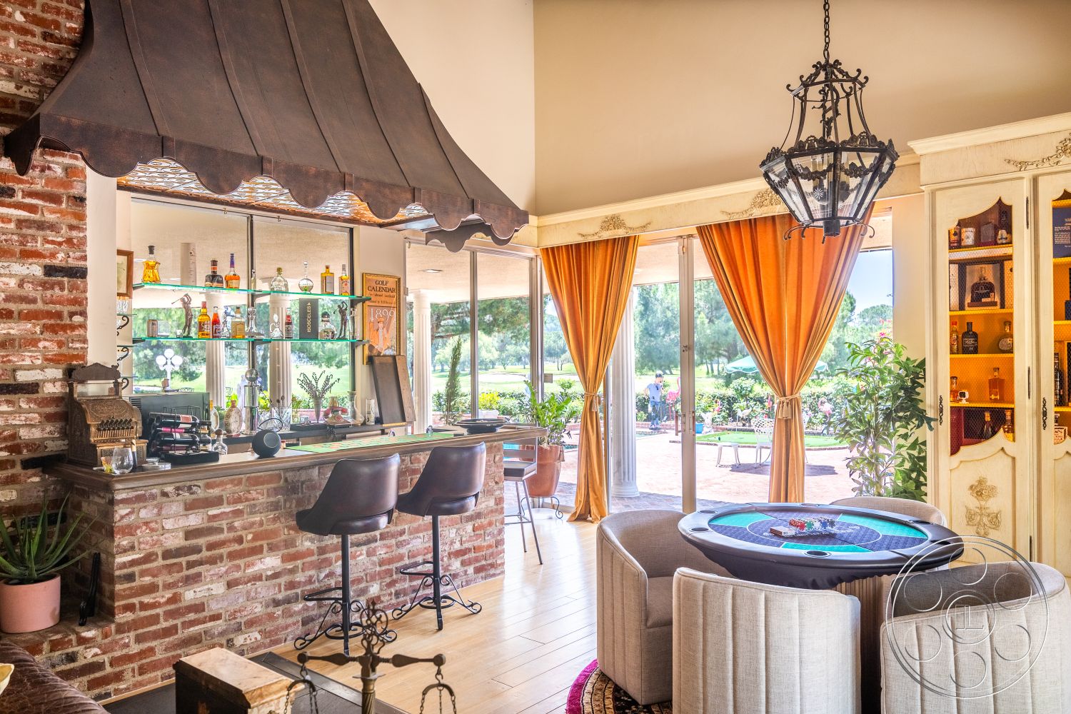 Euphoria - hardwood floor, contemporary bar stools, metal chandelier, exposed brick accent wall, game table, stone bar countertop, hanging metal awning, glass bar shelves, orange drapery