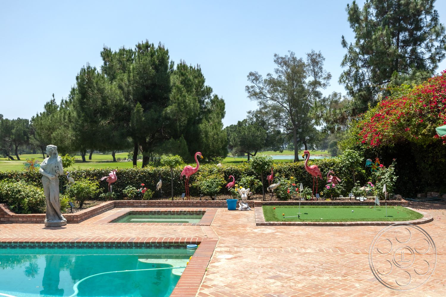 Euphoria - exterior, rectangular swimming pool, lush green lawn, brick patio flooring, mature trees surrounding property, statue garden feature, brick pool border, golf course view, pool spa area, landscape garden with floral shrubs, decorative flamingo yard ornaments, southern landscaping style